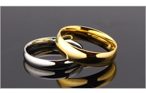 Macro shot of polished silver and gold titanium steel minimalist rings with mirror reflection