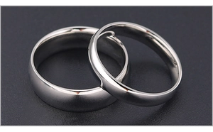 Close-up of polished titanium steel couple rings with sleek silver domed finish