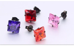 Détail macro de boucles d'oreilles en zircone carrées avec monture en acier noir