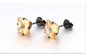 Détail de boucles d'oreilles carrées en zircon champagne avec monture à griffes noires