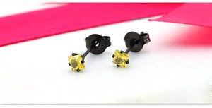 Gros plan de boucles d'oreilles en zircone jaune carrée avec monture quatre griffes en acier noir