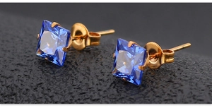 Vue détaillée des boucles d'oreilles carrées en zircon bleu avec monture dorée