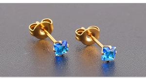 Détail macro de boucles d'oreilles carrées zircon bleu roi 3mm avec griffes en acier doré