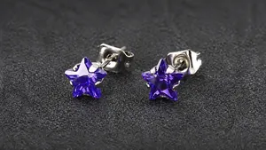 Vue détaillée des boucles d'oreilles étoile en zircone violette avec tiges en acier
