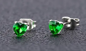 Vue macro de boucles d'oreilles cœur en zircon vert 4mm avec serti à griffes sur métal