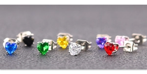 Détail macro de boucles d'oreilles en zircon multicolore en forme de cœur et acier argenté