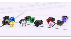 Détail macro de boucles d'oreilles cœur en zircone colorée avec base en métal noir