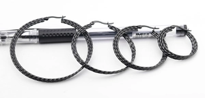 Detail showing four sizes of black woven texture titanium steel hoop earrings with a pen