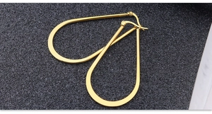 Close-up of polished gold teardrop hoop earrings with high-shine mirror finish