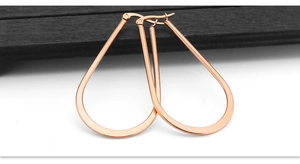 Macro shot of large rose gold teardrop hoop earrings with polished flat metal finish