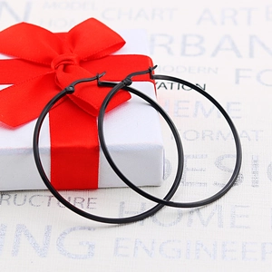 Matte black stainless steel hoop earrings showcased next to a white gift box with red ribbon