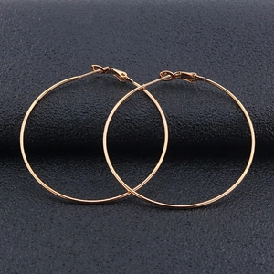 Classic minimalist gold stainless steel hoop earrings for women on black leather