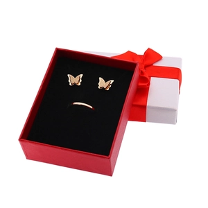 Dettaglio degli orecchini a farfalla e anello in oro rosa in confezione regalo rossa