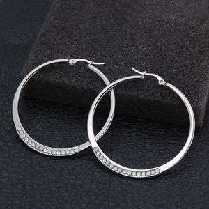 Aros de acero inoxidable plateado con circonitas brillantes sobre una base de piedra negra