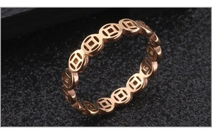 Detail view of rose gold cutout coin ring featuring traditional lucky coin patterns