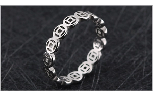 Macro shot of silver titanium steel ring with traditional hollow coin pattern design