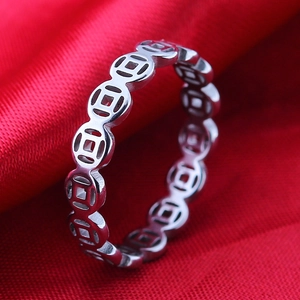 Minimalist silver steel coin ring with hollow design on red fabric background