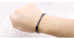 Polished minimalist black titanium steel cuff bangle worn on a wrist for a sleek style