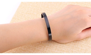 Polished black stainless steel open cuff bracelet shown on wrist with minimalist design