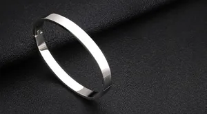 Close-up of a polished silver stainless steel cuff bracelet with a mirror finish