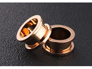 Detailed side view of rose gold stainless steel ear tunnels with mirror polished finish