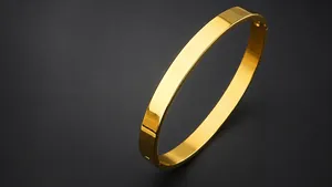 Detailed view of gold plated stainless steel bangle with polished flat surface and hinge
