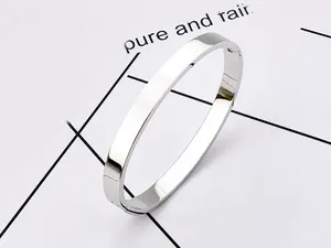 Close-up of minimalist polished stainless steel bangle with hidden clasp on white background