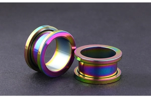 Macro shot of rainbow titanium steel double flare ear plugs with smooth metallic finish