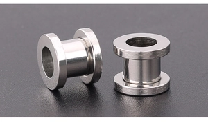 Detailed macro view of polished stainless steel ear tunnels with hollow cylindrical design