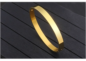 Detail view of gold titanium steel bangle with polished finish and side buckle closure