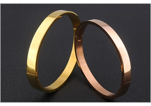 Detail of high-polished gold and rose gold stainless steel minimalist hinged bangles