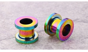 Macro view of rainbow stainless steel hollow ear tunnels with vibrant iridescent finish
