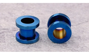Macro view of blue stainless steel ear tunnels with rainbow gradient interior detail