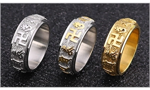 Vista macro de anillos giratorios de acero de titanio con mantras budistas grabados
