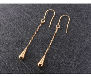 Detail van roségouden lange kettingoorbellen met gepolijste waterdruppel hangers