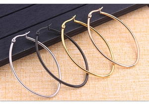 Close-up of oversized oval hoop earrings in silver, gold, black, and rose gold finishes