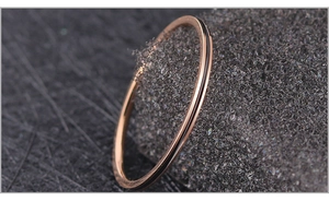Vue macro d'une bague fine en acier rose doré avec un élégant détail en émail noir