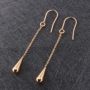 Elegante gouden titanium stalen lange druppeloorbellen met U-haken op zwart leer ondergrond