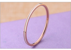 Gros plan d'une bague fine en acier inoxydable or rose avec émail blanc pour femme