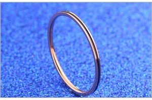 Macro d'une bague en acier titane or rose avec rainure minimaliste en émail noir fin