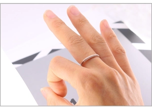 Gros plan d'une bague fine minimaliste en acier inoxydable doré rose sur le doigt