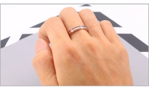 Détail de la bague en acier inoxydable or rose avec rayures blanches et marron épurées