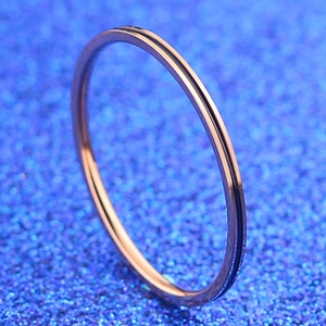 Bague minimaliste en acier inoxydable or rose avec ligne en émail noir en gros plan