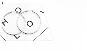 Detail view showing hollow round wire design of polished silver stainless steel hoop earrings
