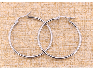 Detailed top-down view of silver stainless steel hoop earrings on orange woven fabric