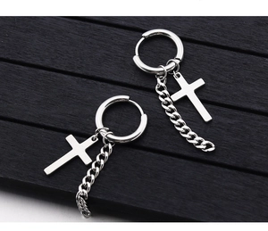 Vue macro de boucles d'oreilles créoles en acier titane argenté avec croix et chaîne