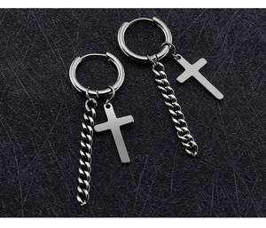 Détail de boucles d'oreilles en acier titane argenté avec chaîne et pendentif croix