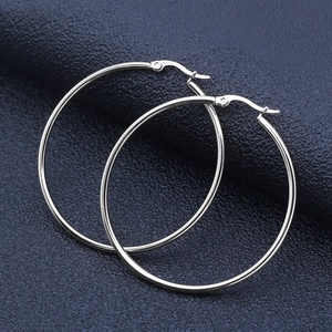 Polished silver stainless steel large hoop earrings on dark textured background