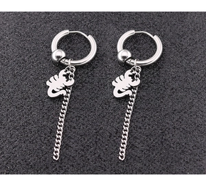 Détail de boucles d'oreilles punk en titane argenté avec pendentif scorpion et chaîne