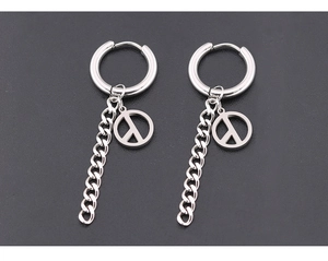 Détail de boucles d'oreilles créoles en acier avec chaîne et pendentif symbole de paix